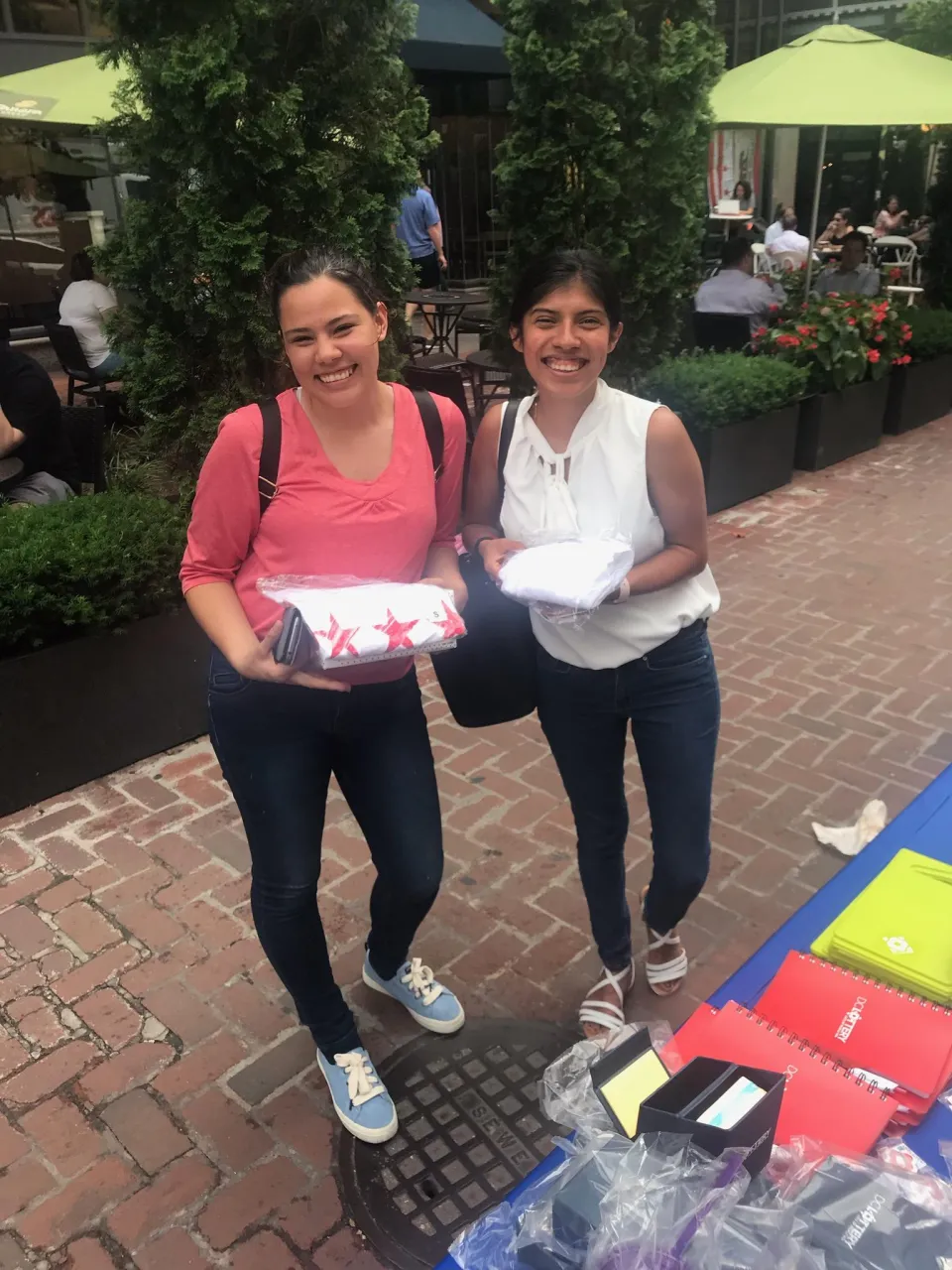 two woman holding t-shirts