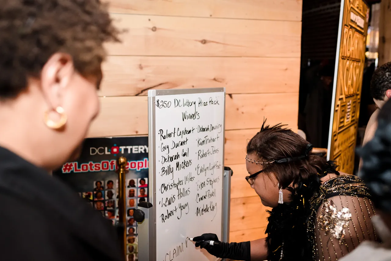 Woman writing winner names on a white board